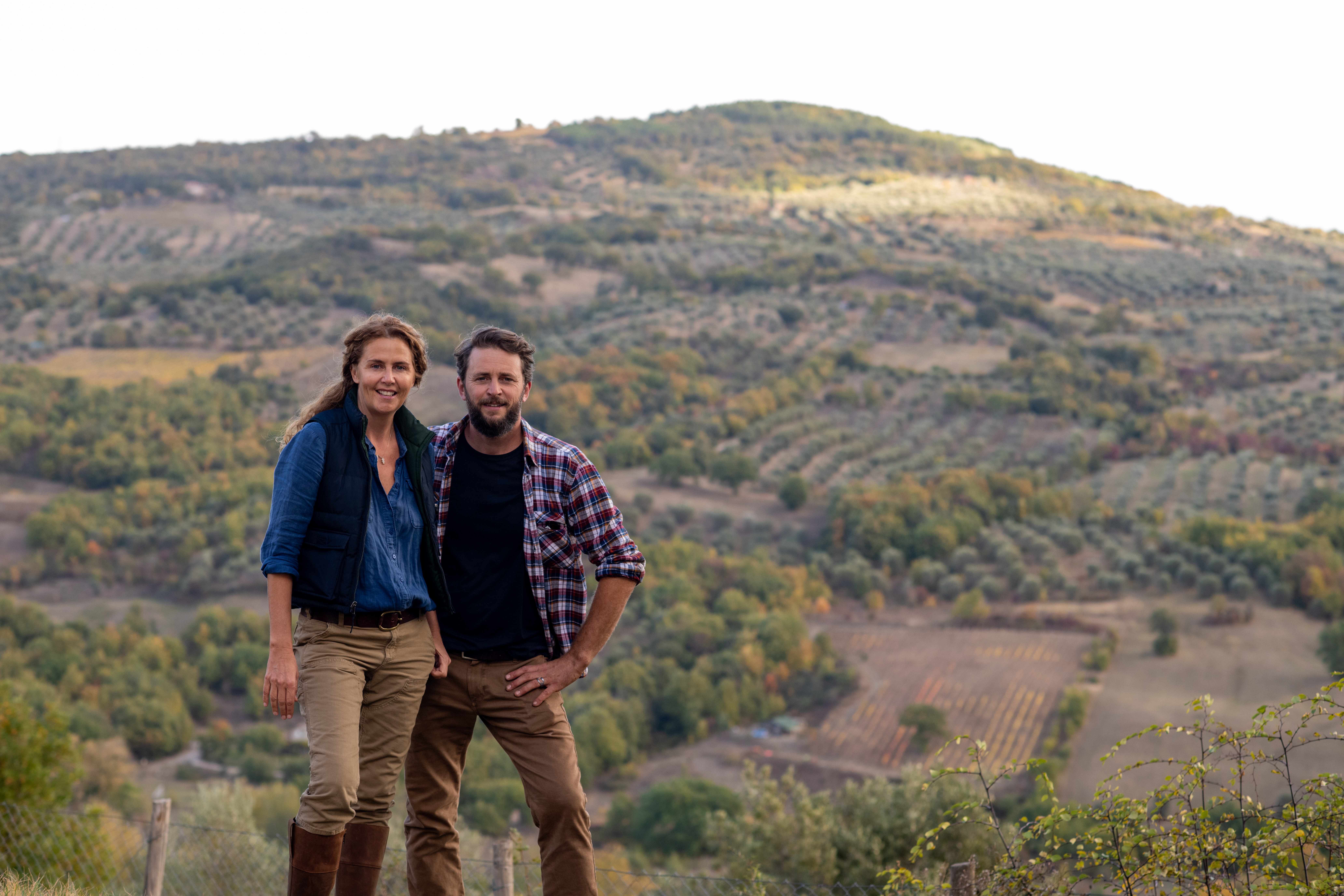 Siblings Marie-Charlotte Piro and Romain Piro stand among some of the olive trees they harvest in Tuscany, Italy, to create their olive oil. Their Olio Piro startup had been exporting all its olive oil to the United States — until new U.S. tariffs moved up their plans to start expanding elsewhere.